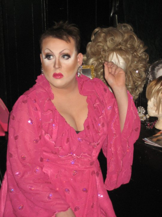 drag queen in a pink dress getting ready